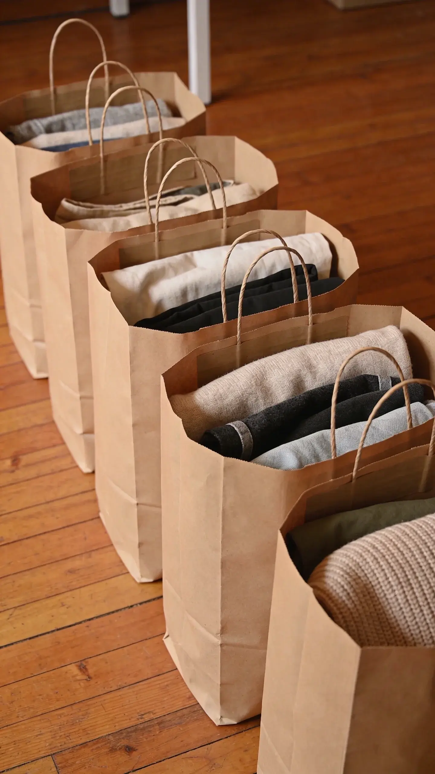 neatly folded donation pile in kraft bags on floor