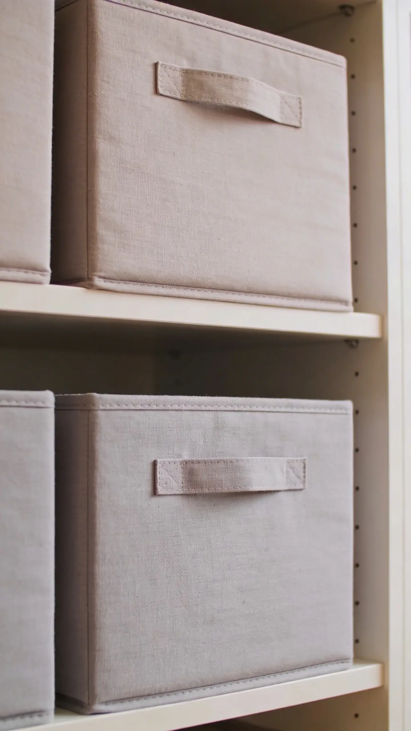 labeled fabric bins on top shelf, neutral tones